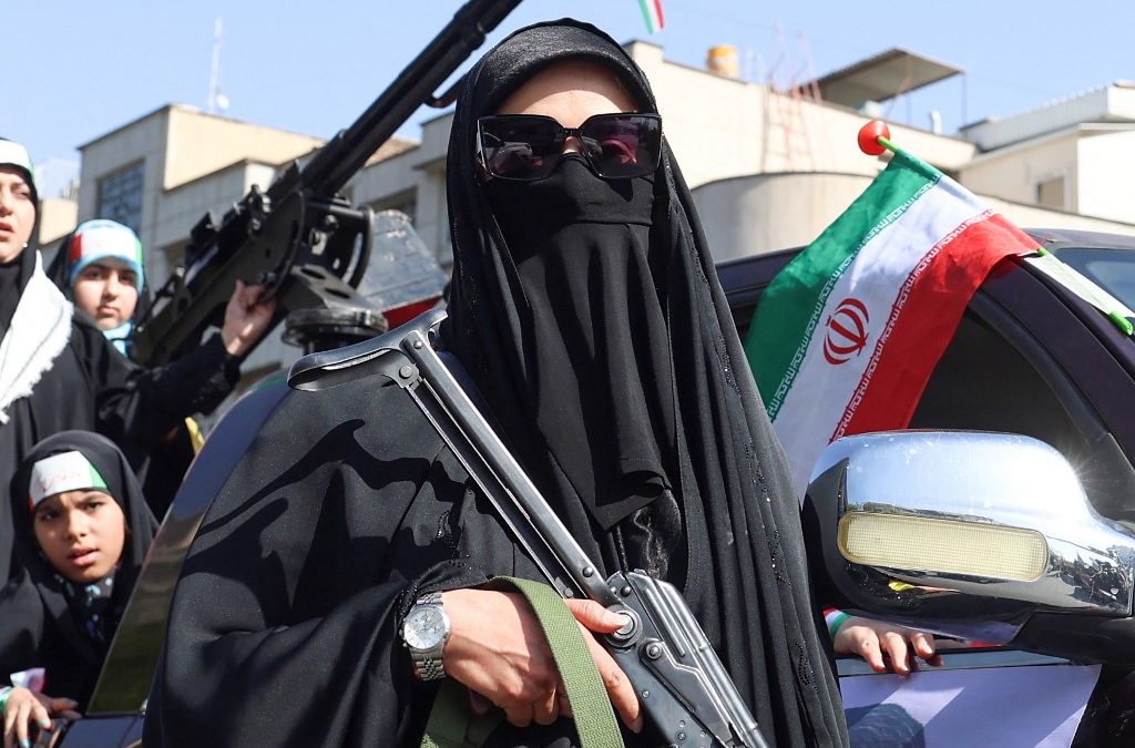 Una mujer iraní empuña un rifle durante una manifestación denominada «Chicas Sacrificadas» para rendir homenaje a las mujeres asesinadas durante la guerra de Oriente Medio en Teherán el 17 de abril de 2026. Foto de AFP