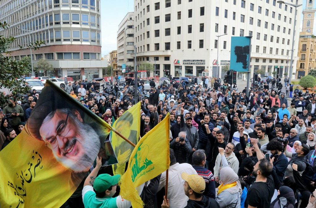 Simpatizantes de Hezbolá ondean una bandera con el retrato del líder asesinado de Hezbolá, Hassan Nasrallah, durante una protesta antigubernamental frente al palacio de gobierno libanés en Beirut, el 9 de abril de 2026. Ibrahim AMRO / AFP