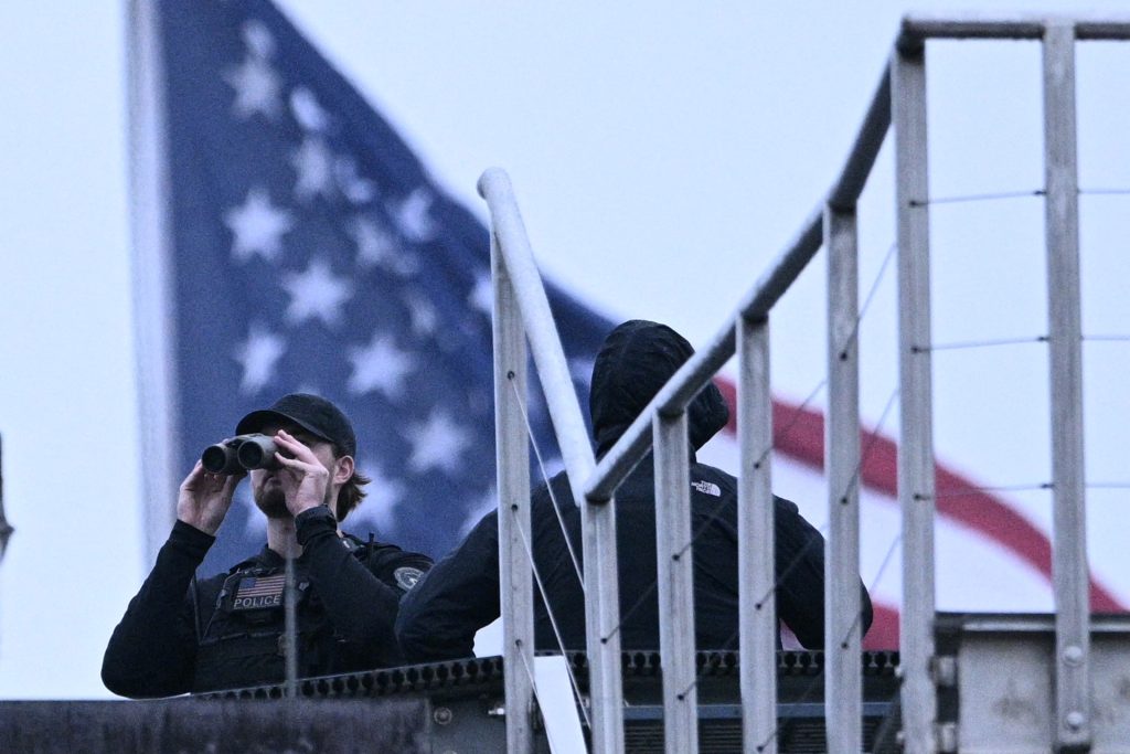 Policía utiliza binoculares en el tejado de un edificio de la Casa Blanca, tras los presuntos disparos ocurridos el 23 de mayo de 2026.
