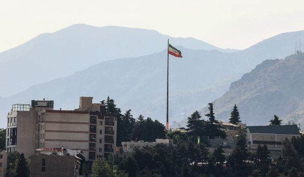 La bandera iraní ondea en un alto mástil sobre rascacielos en el norte de Teherán el 12 de mayo de 2026. El principal negociador iraní declaró ese mismo día que Washington debía aceptar el último plan de paz de Teherán o se enfrentaría al fracaso. FOTO: AFP/ATTA KENARE