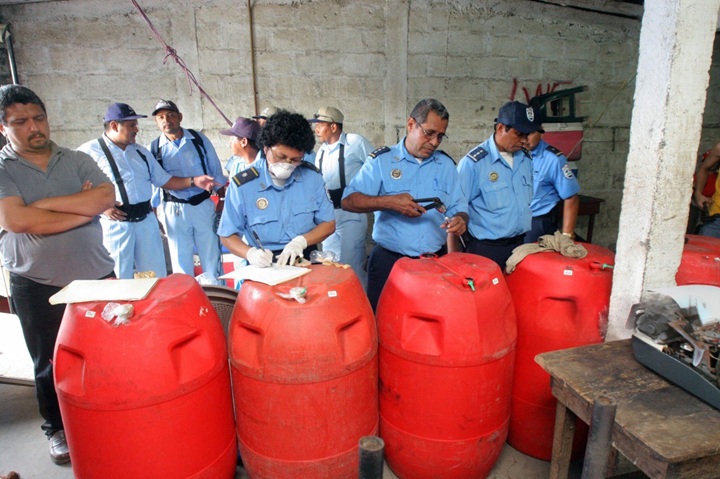 Agentes policiales y personal del Ministerio de Salud (Minsa) toman muestras de barriles con licor sospechoso de contaminación con metanol en un mercado de León. Para el 9 de septiembre de 2006, la tragedia ya sumaba 25 fallecidos y más de un centenar de intoxicados por el consumo de este aguardiente adulterado. LA PRENSA / MIGUEL ÁLVAREZ / AFP