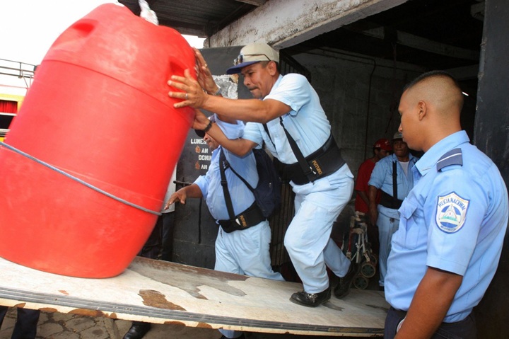 Personal del Ministerio de Salud (Minsa) traslada un barril de aguardiente adulterado con metanol, decomisado en el mercado de León. LA PRENSA / MIGUEL ÁLVAREZ / AFP
