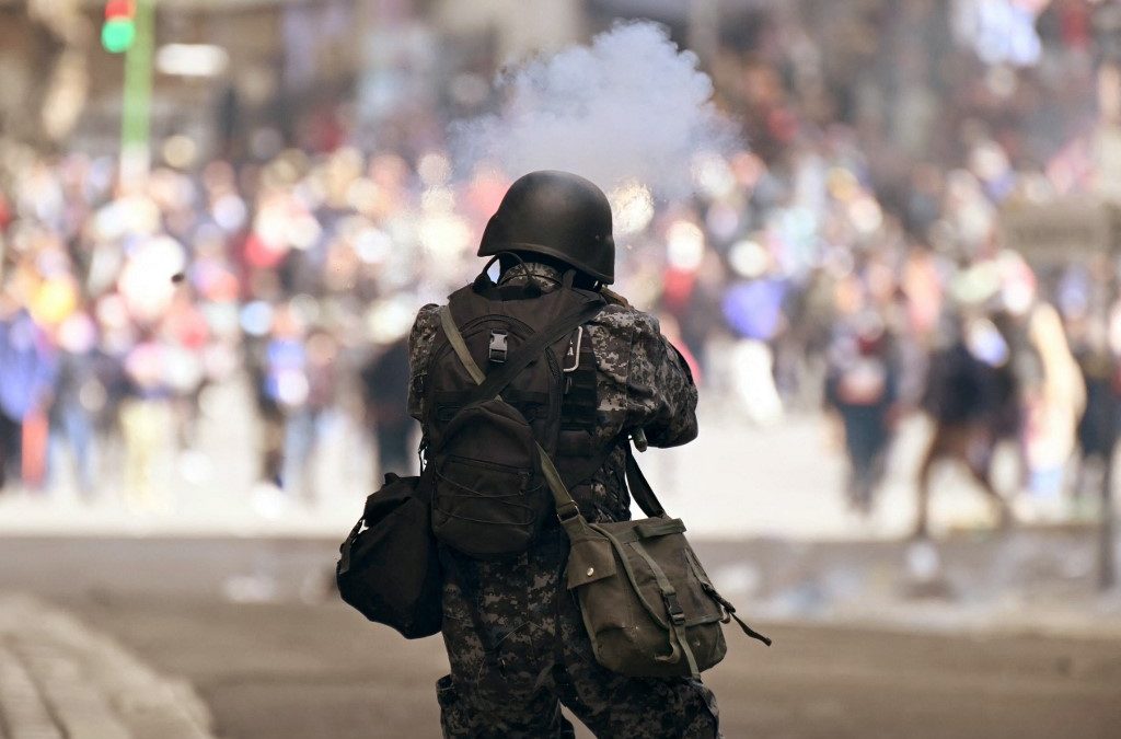 Un policía dispara hacia un grupo de manifestantes, en La Paz. MARVIN RECINOS/AFP