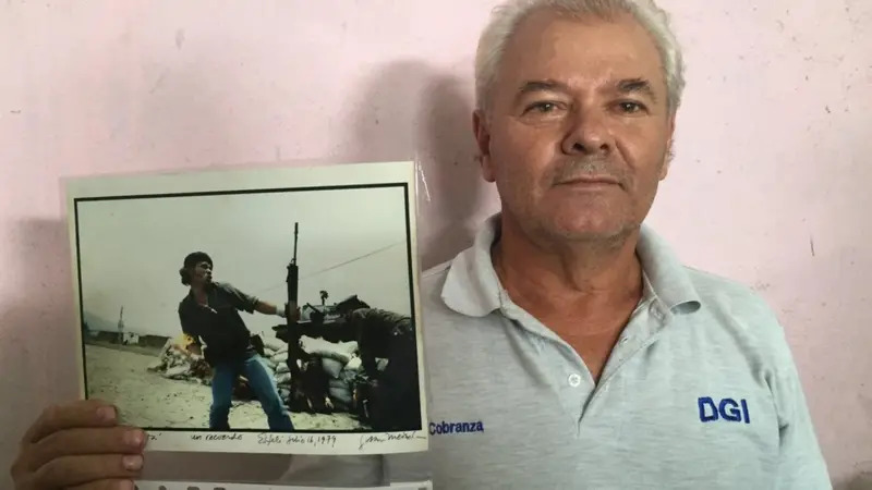 Pablo Jesús Arauz aparece sosteniendo la fotografía que lo hizo muy reconocido como guerrillero sandinista. Foto: BBC.