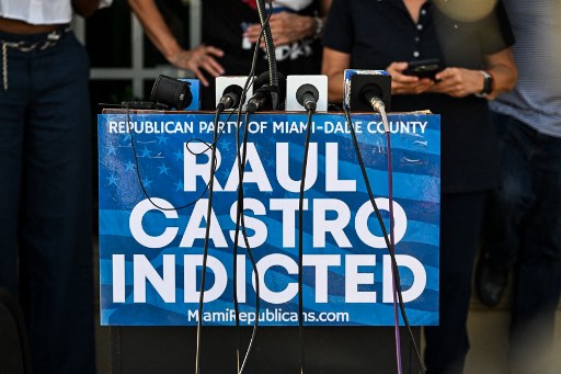 A sign on a lectern reads "Republican Party of Miami-Dade County, Raul Castro Indicted" as people gather outside Versailles Restaurant in support of charges announced by US federal prosecutors against the former Cuban president in Miami, Florida, on May 20, 2026.