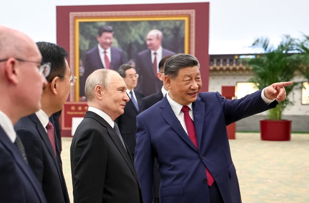 En esta fotografía compartida por la agencia estatal rusa Sputnik, el presidente ruso Vladimir Putin y el presidente chino Xi Jinping visitan una exposición fotográfica sobre las relaciones entre Rusia y China en Pekín el 20 de mayo de 2026. (Foto de Alexander KAZAKOV / POOL / AFP)