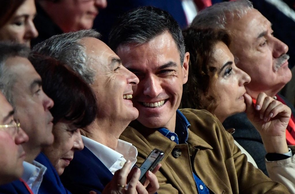 El presidente del Gobierno de España y secretario general del Partido Socialista Obrero Español (PSOE), Pedro Sánchez (c), sonríe junto al expresidente José Luis Rodríguez Zapatero (izq.) durante el 41.º congreso del Partido Socialista Obrero Español, celebrado en el Palacio de Exposiciones de Sevilla el 30 de noviembre de 2024. CRISTINA QUICLER / AFP