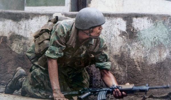 Un soldado de la Guardia Nacional se cubre del fuego guerrillero de los sandinistas en uno de los barrios de Managua. LA PRENSA / OLIVER REBBOT