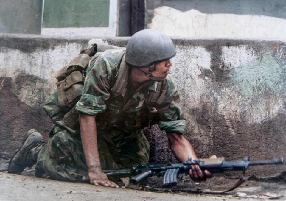 Un soldado de la Guardia Nacional se cubre del fuego guerrillero de los sandinistas en uno de los barrios de Managua. LA PRENSA / OLIVER REBBOT