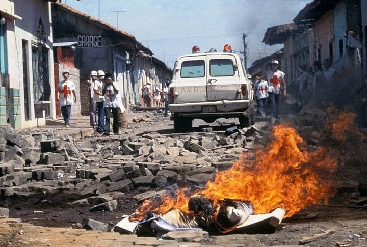 Voluntarios de la Cruz Roja observan la quema de un cadáver durante la ofensiva final. Julio de 1979. LA PRENSA / MATTHEW NAYTHONS