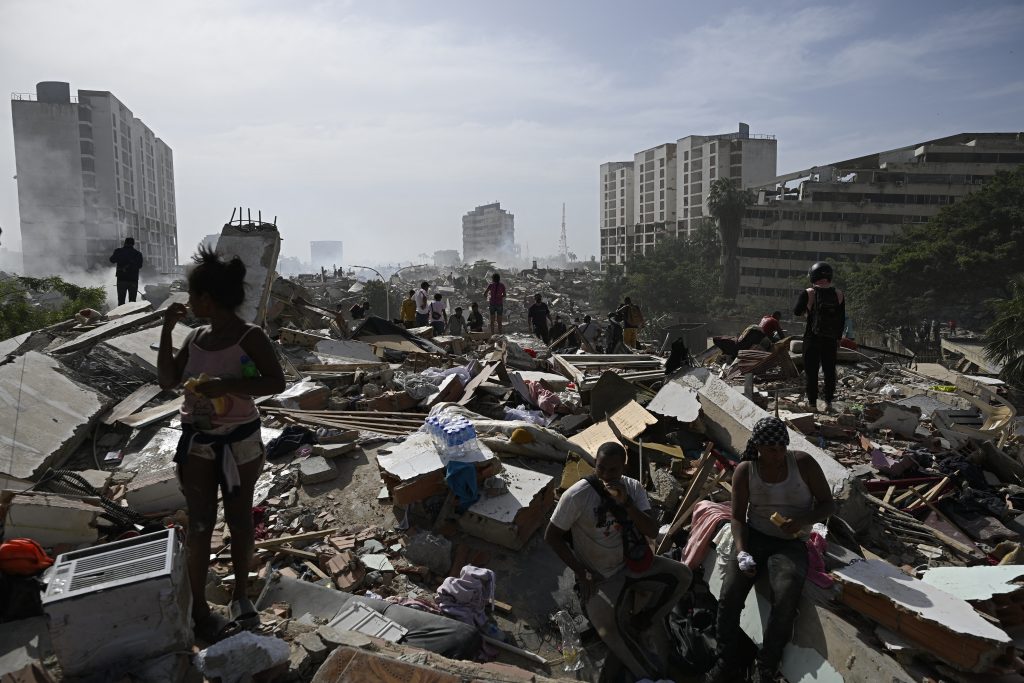 Habitantes de la zona de Caraballeda, en el estado de La Guaira, caminan entre los escombros de viviendas y calles tras el doble terremoto en Venezuela. AFP/Federico Parra