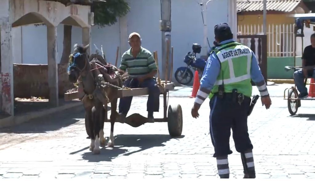 Agente de tránsito regula el tráfica en una calle central de San Rafael del Sur, Managua