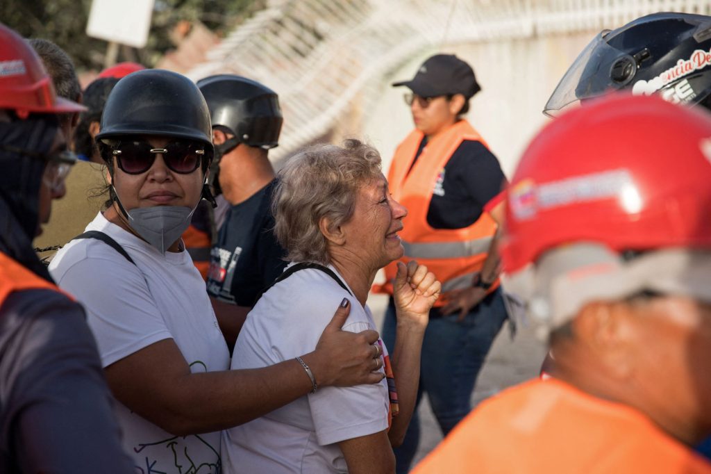 Una señora llora mientras los rescatistas hurgan entre los escombros de un edificio en Caraballeda, en La Guaira. Se estima que hay miles de personas aún bajo los escombros. DONALDOBARROS/AFP