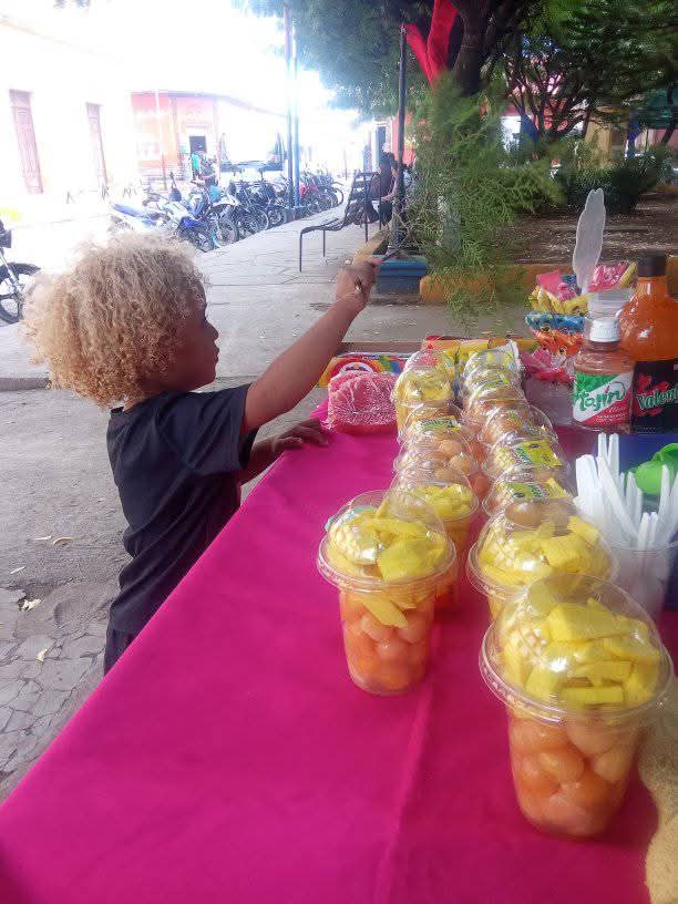 Colochito vendiendo en el puesto de su madre. Foto: Cortesía/Melissa Pastrán.