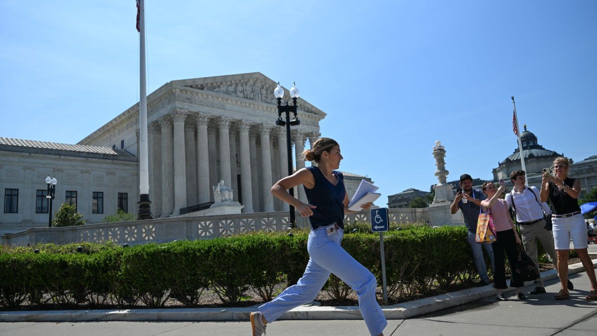 Una reportera corre frente a la Corte Suprema de Estados Unidos para garantizar una cobertura noticiosa tras el anuncio del tribunal sobre el tema de la ciudadanía por nacimiento en ese país. Alex WROBLEWSKI / AFP