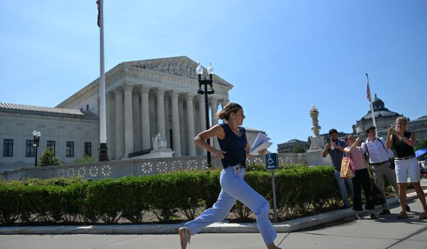 Una reportera corre frente a la Corte Suprema de Estados Unidos para garantizar una cobertura noticiosa tras el anuncio del tribunal sobre el tema de la ciudadanía por nacimiento en ese país. Alex WROBLEWSKI / AFP