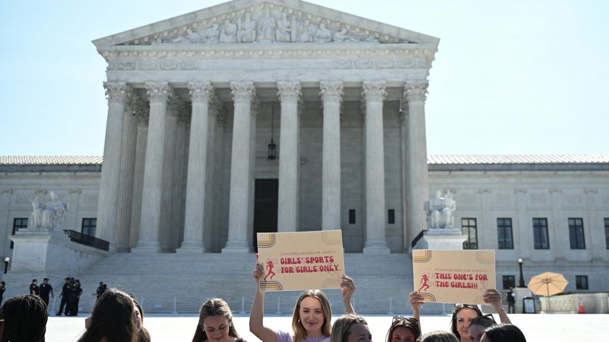 Mujeres jóvenes se manifiestan frente a la Corte Suprema de Estados Unidos mientras el tribunal ratificaba las leyes estatales que prohíben a las atletas transgénero competir en deportes escolares femeninos en Washington, D.C., el 30 de junio de 2026. (Foto de Alex WROBLEWSKI / AFP)