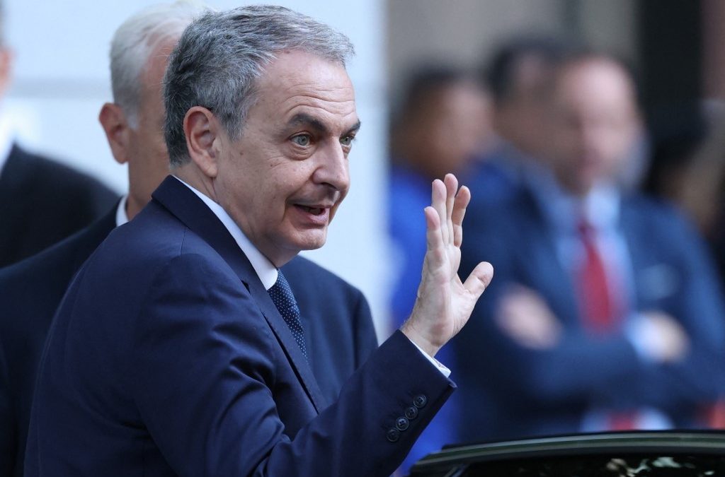 El expresidente del Gobierno español, José Luis Rodríguez Zapatero, saluda a su llegada al juzgado de Madrid para ser interrogado en el marco de una investigación por presunto tráfico de influencias, el 17 de junio de 2026. El caso gira en torno al rescate estatal de 53 millones de euros a la pequeña aerolínea Plus Ultra en 2021 y si Zapatero utilizó su influencia para obtener el dinero a cambio de comisiones. (Foto de Thomas COEX / AFP)