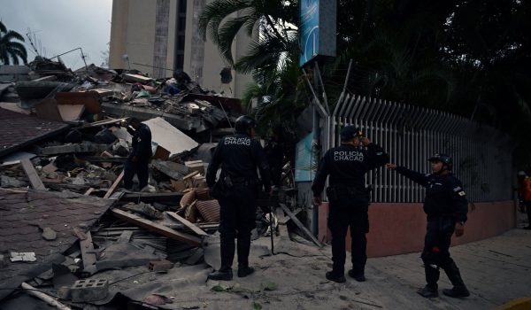 Agentes de la policía municipal se encuentran junto a los restos de una estructura derrumbada tras el terremoto que sacudió Caracas el 24 de junio de 2026. El sismo alcanzó una magnitud de 7,1, según el Servicio Geológico de Estados Unidos (USGS).