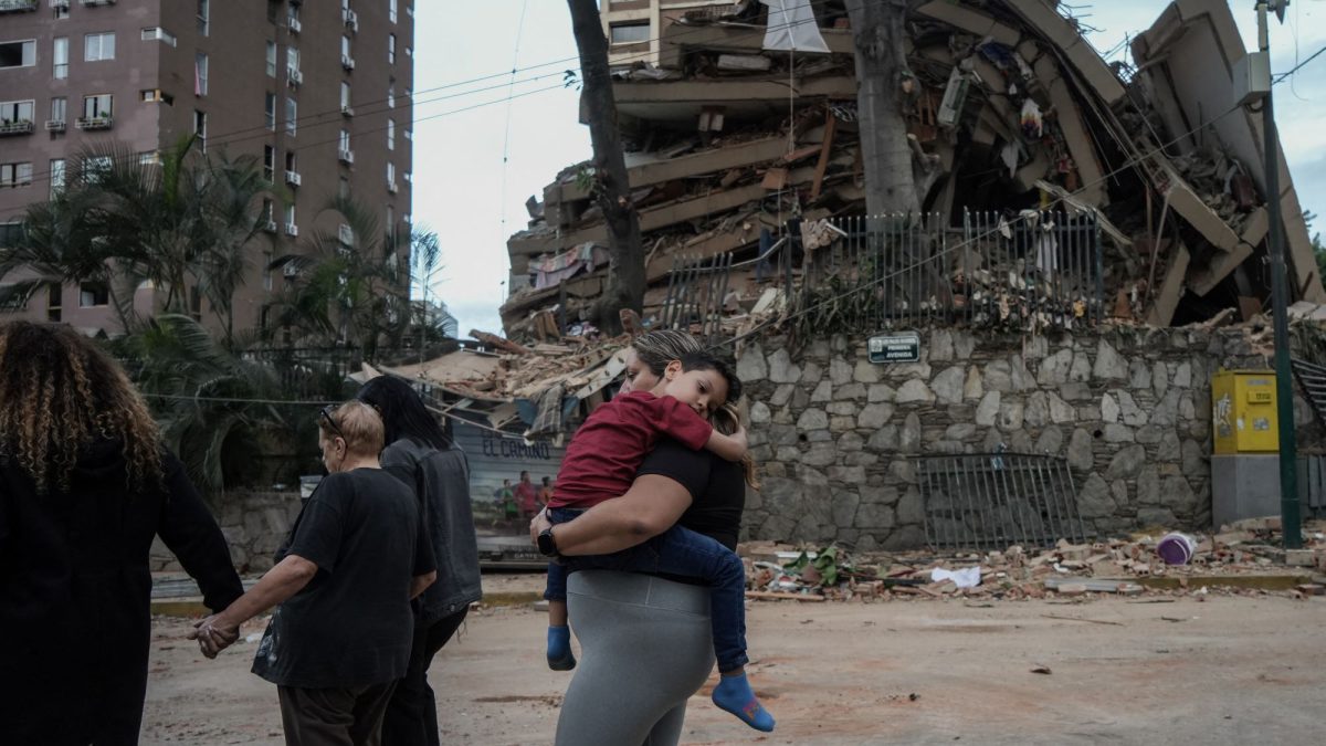 Una familia camina al lado de edificios derruidos en Caracas, tras dos terremotos consecutivos que estremecieron Venezuela el miércoles. MANAURE QUINTERO/AFP