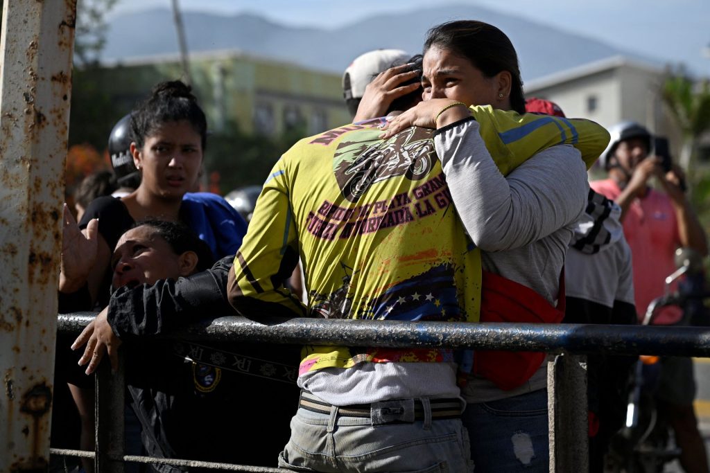 Dos personas se abrazan después de lograr sobrevivir a los intensos terremotos que impactaron Catia La Mar y a toda Venezuela el miércoles 24 de junio de 2026. FEDERICO PARRA/AFP