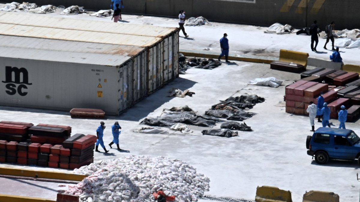 Expertos forenses alinean cadáveres en el suelo junto a ataúdes en el puerto de La Guaira, estado de La Guaira, Venezuela, el 29 de junio de 2026, tras los dos terremotos ocurridos el 24 de junio. JUAN BARRETO/AFP
