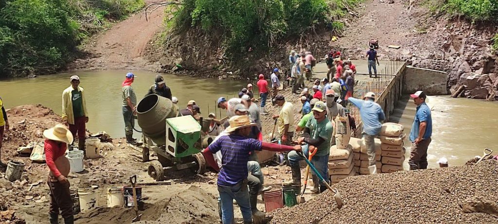 Productores y habitantes de El Dorado, San Miguelito, trasladando en baldes parte del cemento necesario para la plataforma del puente El Cojo. Foto: Tomada de la Alcaldía de San Miguelito.