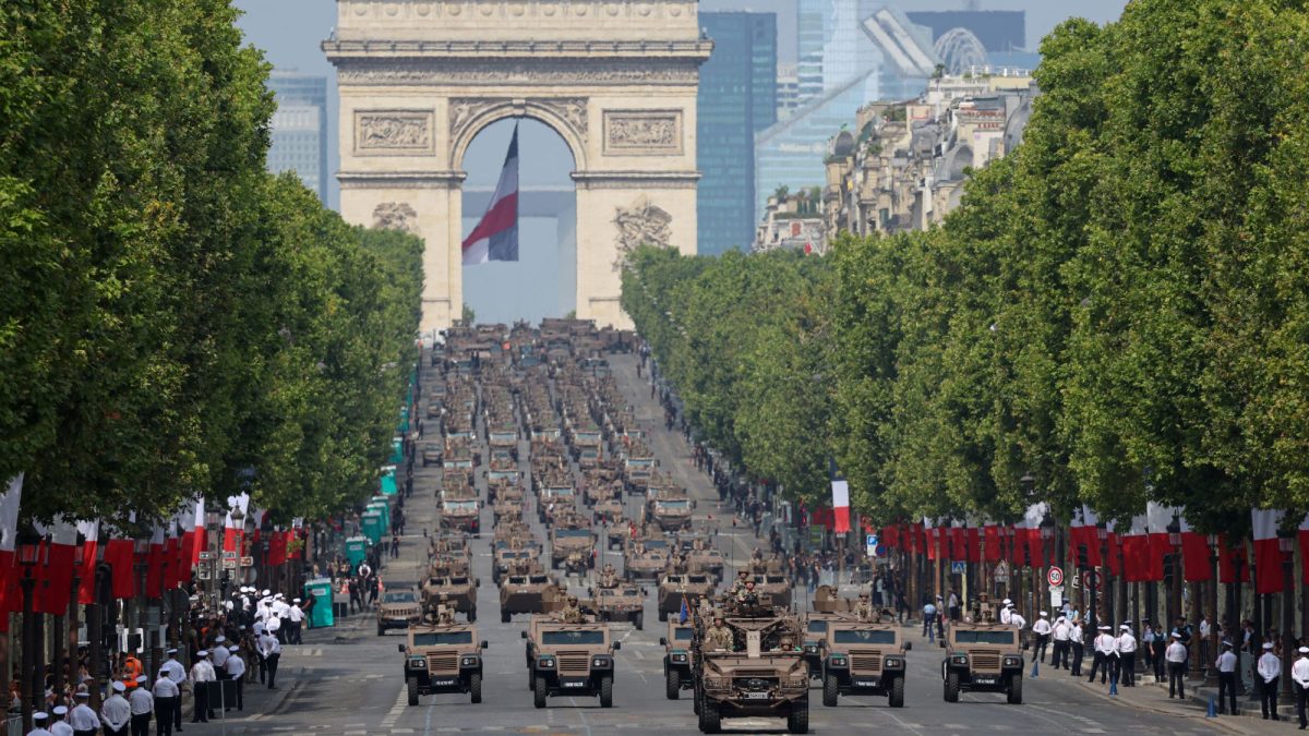 Una unidad de vehículos blindados del Ejército francés avanza por la avenida de los Campos Elíseos, París, durante el tradicional desfile militar celebrado hoy en el aniversario del Día de la Bastilla, la fiesta nacional de Francia. AFP