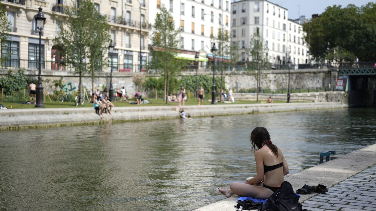 Varios parisinos se refrescan a orillas del Sena en París a finales del pasado mes, en una fotografía de archivo. EFE/ Edgar Sapiña