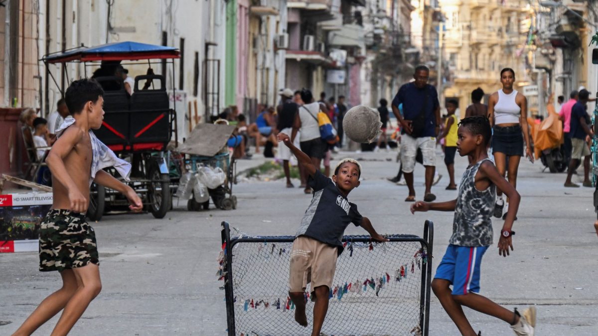 Unos niños juegan al fútbol y se divierten en la calle en el centro de La Habana durante un apagón. YAMIL LAGE/AFP