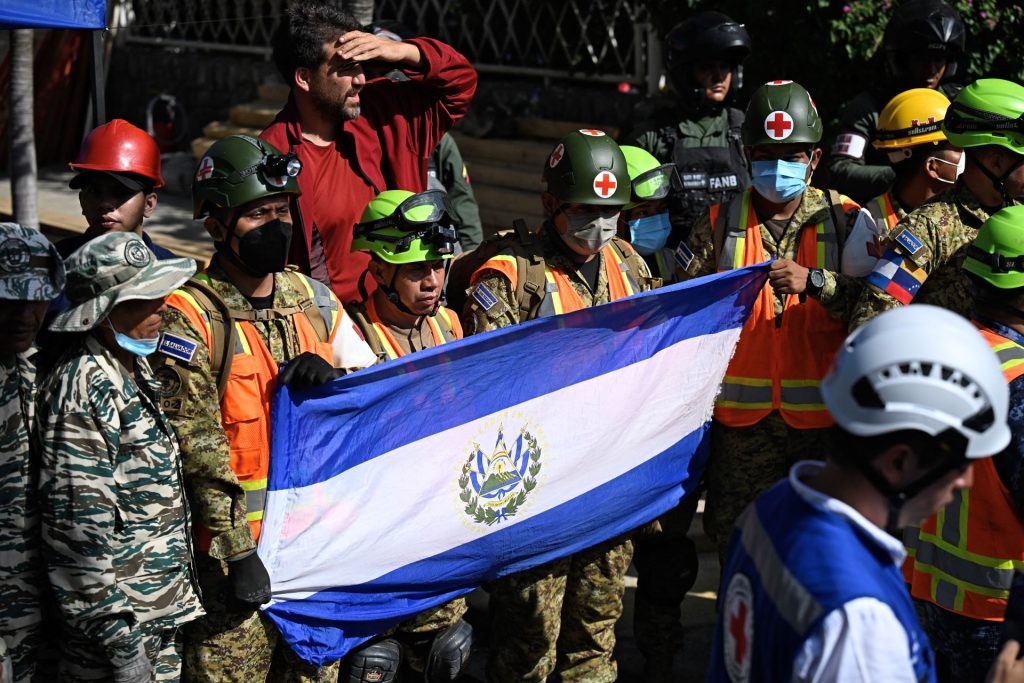 Miembros del equipo de socorro de El Salvador que participaron en la operación de rescate de Hernán Gil celebran y despliegan su bandera nacional. FEDERICO PARRA/AFP