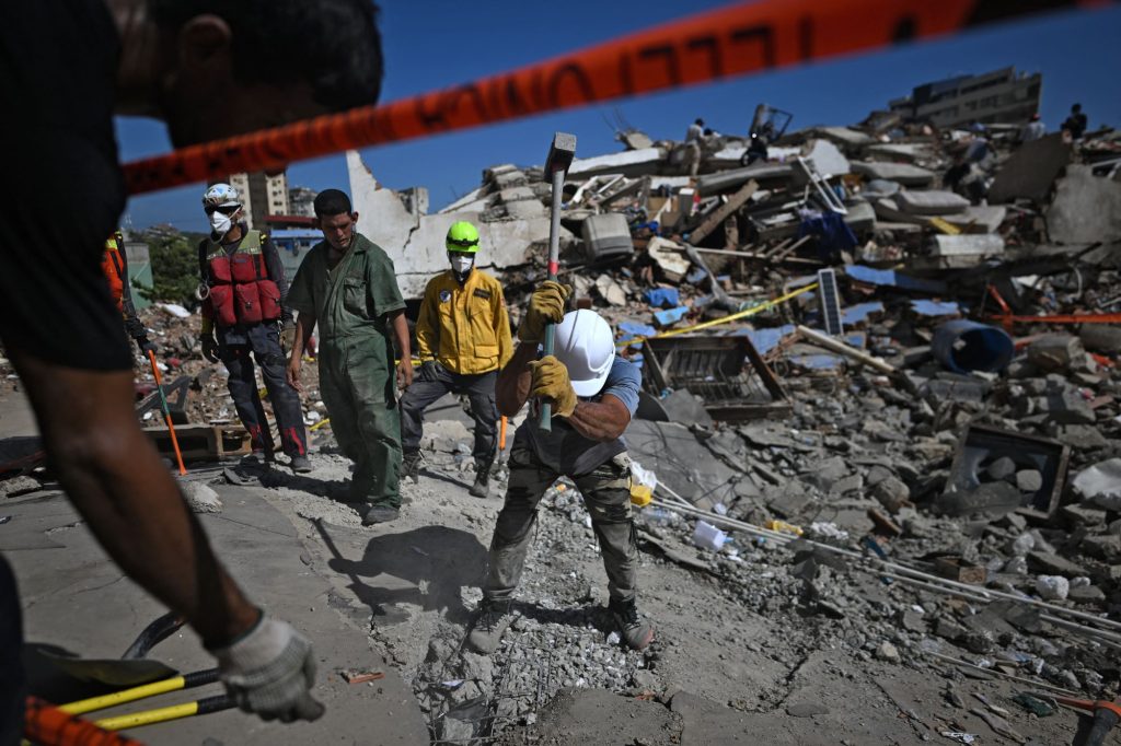Aferrándose a la esperanza, un grupo de rescatistas sigue buscando víctimas en edificios destruidos en Playa Los Cocos, en Caraballeda, La Guaira, JUAN BARRETO/AFP