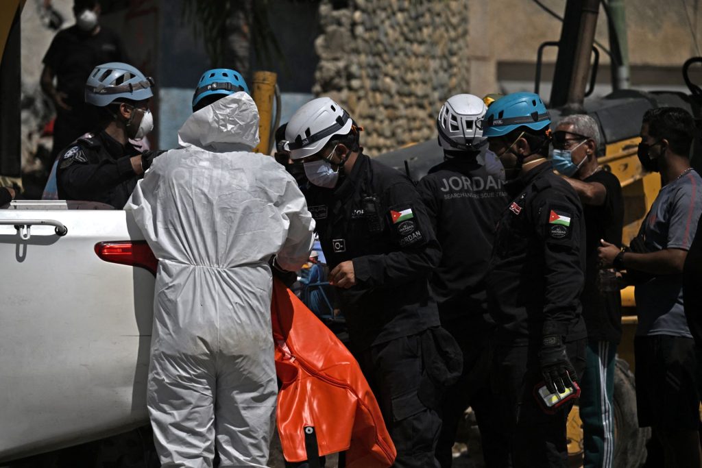 Rescatistas jordanos colocan un cadáver en una camioneta en Caraballeda, La Guaira. JUAN BARRETO/AFP
