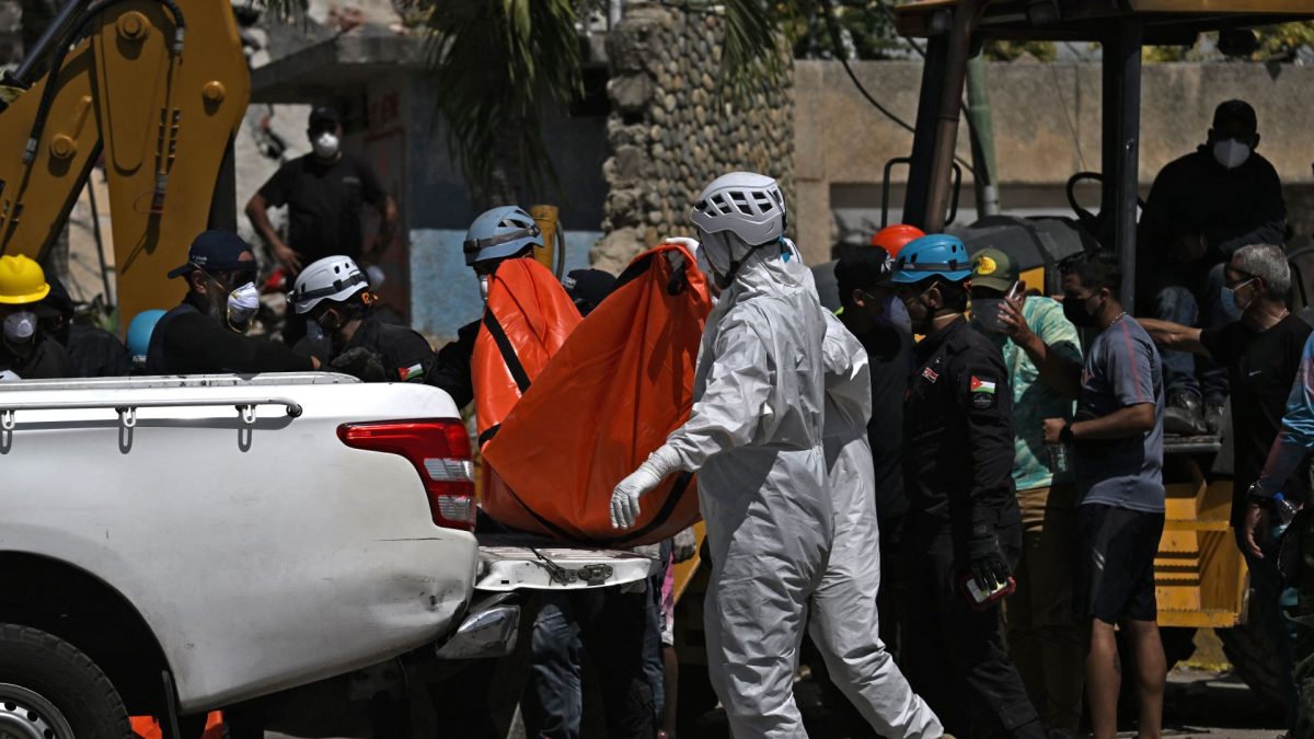 Rescatistas jordanos colocan un cadáver en una camioneta en Caraballeda, La Guaira. JUAN BARRETO/AFP
