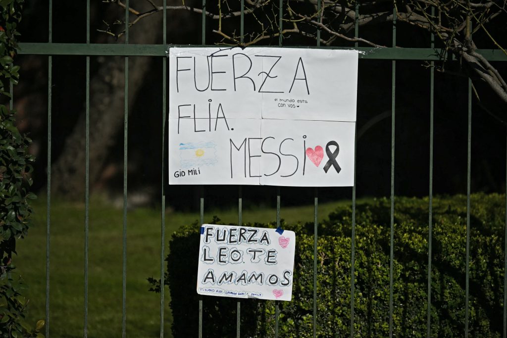 Carteles con los mensajes "Fuerte familia Messi" y "Fuerte Leo, te queremos", dejados por los aficionados, se ven en la valla del cementerio El Prado, en las afueras de Rosario, provincia de Santa Fe, Argentina, el 9 de agosto de 2026. (Foto de Luis ROBAYO / AFP)