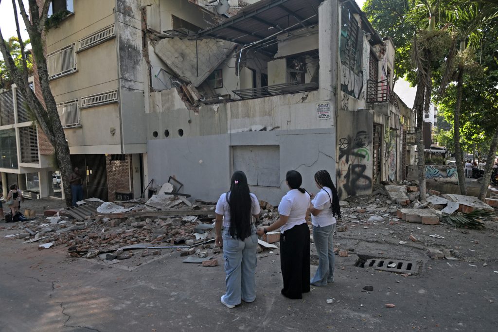 Mujeres observan un edificio dañado tras el terremoto en Cali, Colombia, el 10 de agosto de 2026. (Foto de JOAQUIN SARMIENTO / AFP)