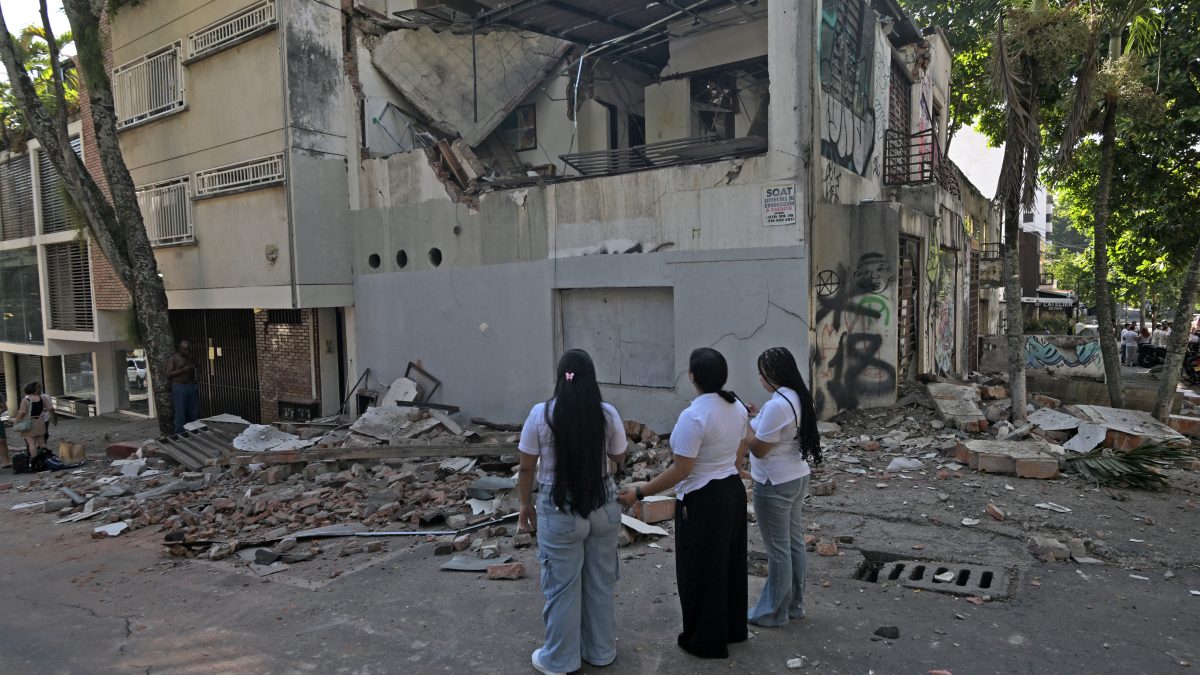 Mujeres observan un edificio dañado tras el terremoto en Cali, Colombia, el 10 de agosto de 2026. (Foto de JOAQUIN SARMIENTO / AFP)