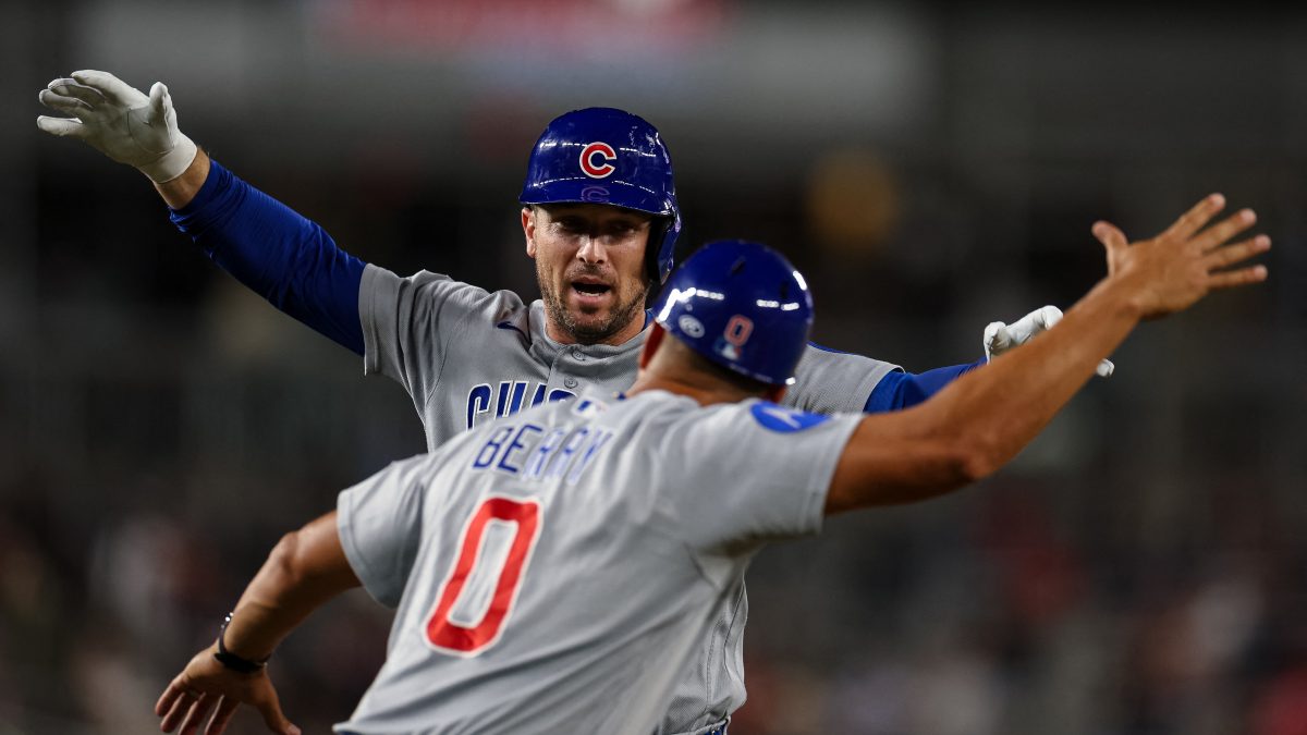 Alex Bregman es saludado por el coach de los Cachorros, Quintin Berry, después de volarse la cerca. LA PRENSA/AFP