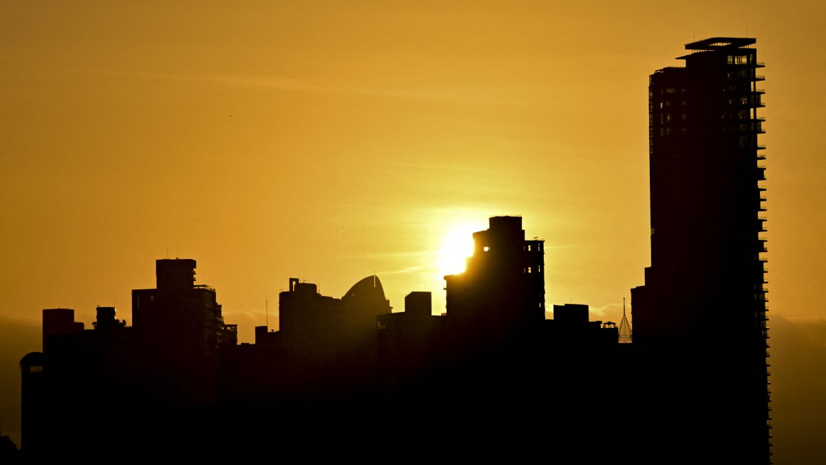 (ARCHIVO) El sol sale sobre el horizonte urbano de la ciudad de Panamá. (Foto de MARTIN BERNETTI / AFP)