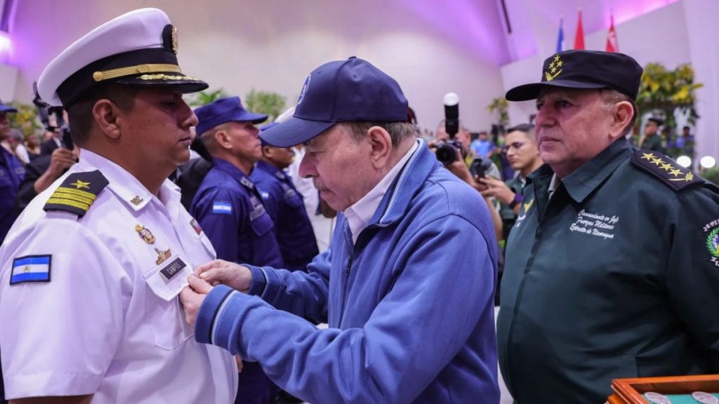 Julio César Avilés detrás del dictador Daniel Ortega mientras esté impone una condecoración a un militar del Ejército. Foto: El 19 Digital.
