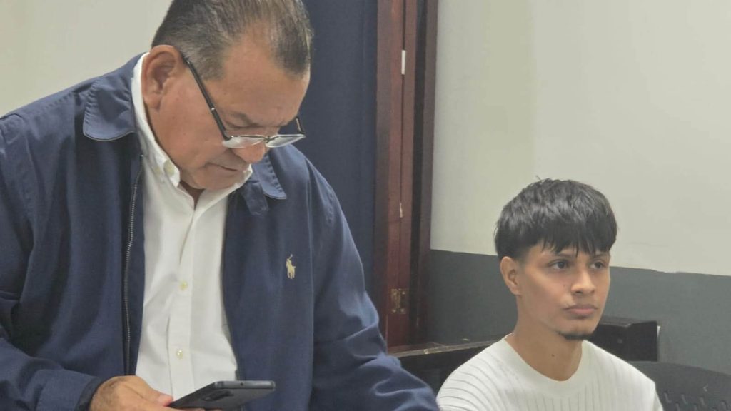 Stewer Jhoan Guzmán (a la derecha) y su abogado defensor ( a la izquierda), en audiencia. Foto: Canal 13.