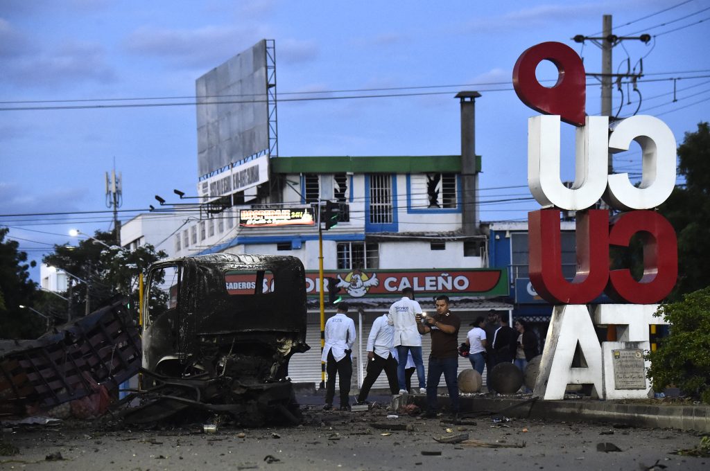 Investigadores forenses y agentes de policía examinan los restos de un atentado con coche bomba cerca de una comisaría en Cúcuta. AFP/Schneyder Mendoza