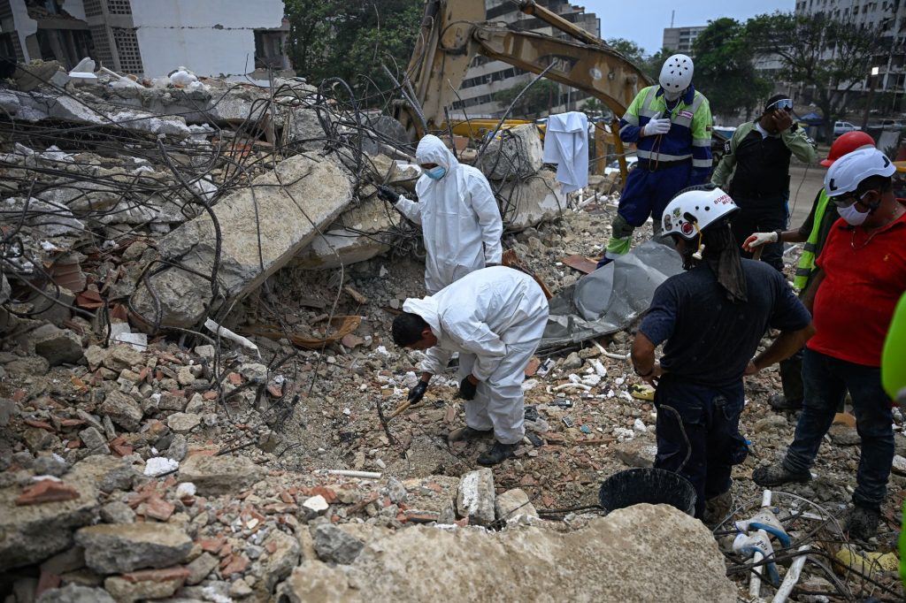 Forenses policiales buscan restos humanos entre las montañas de escombros en Caraballeda. La insuficiente e inadecuada reacción del gobierno chavista a los terremotos del 24 de junio han irritado a los venezolanos. FEDERICO PARRA/AFP