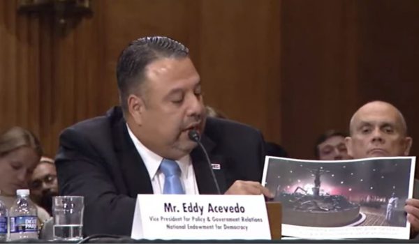 El vicepresidente de Política y Relaciones Gubernamentales de la Fundación Nacional para la Democracia (NED, por sus siglas en inglés), Eddy Acevedo muestra una fotografía de la Sangre de Cristo, hecha por LA PRENSA . Foto: Captura de pantalla