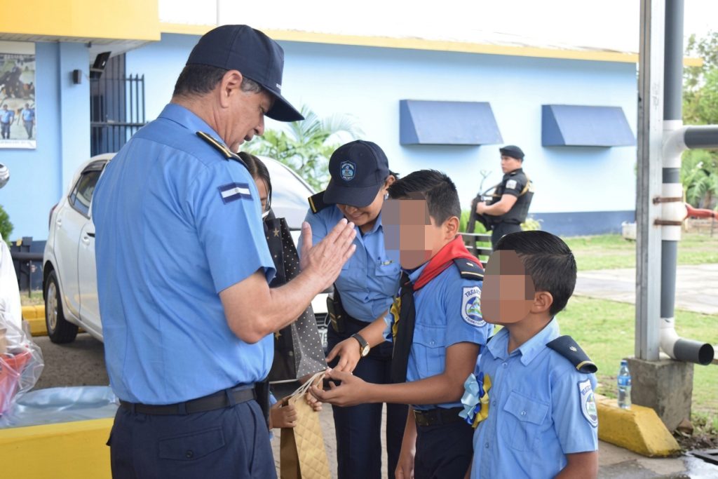 Francisco Díaz, jefe de la Policía Nacional, entrega obsequios a niños vestidos con uniformes similares a los utilizados por miembros de la institución. LA PRENSA / ARCHIVO REDES