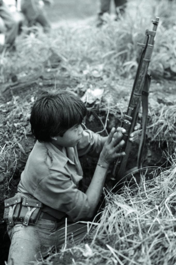 Un menor manipula un fusil ZB vz. 24 desde un pozo de tirador en Managua, en julio de 1988, durante los últimos años de la guerra entre el gobierno sandinista y la Contra. LA PRENSA / ÓSCAR NAVARRETE