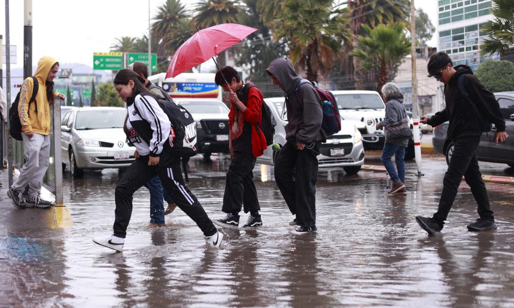 Personas caminan por una calle inundada debido a las fuertes lluvias en Pachuca (México). EFE/ David Martínez Pelcastre