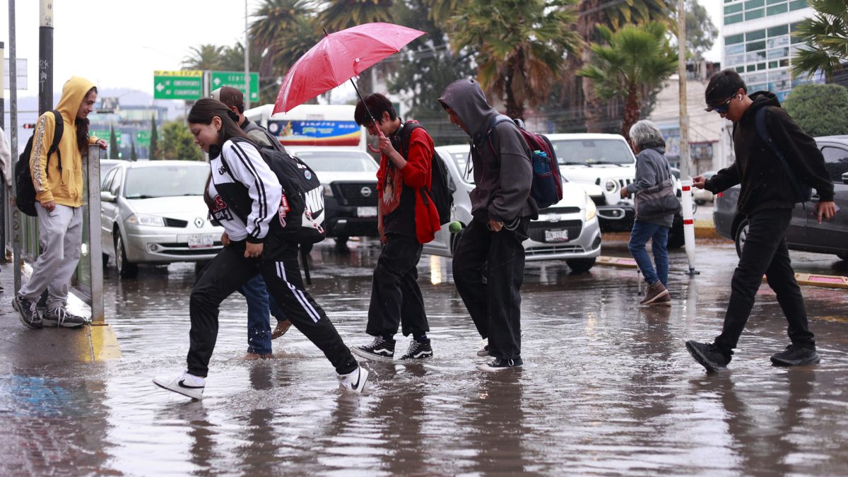 Personas caminan por una calle inundada debido a las fuertes lluvias en Pachuca (México). EFE/ David Martínez Pelcastre