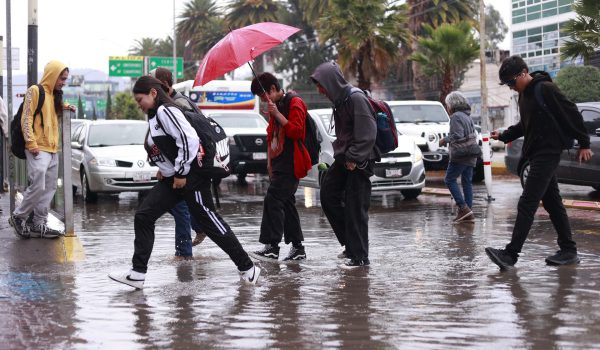 Personas caminan por una calle inundada debido a las fuertes lluvias en Pachuca (México). EFE/ David Martínez Pelcastre