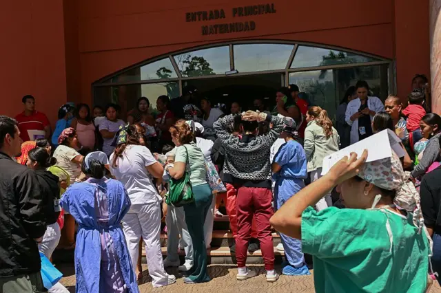 Personas esperan afuera de un edificio